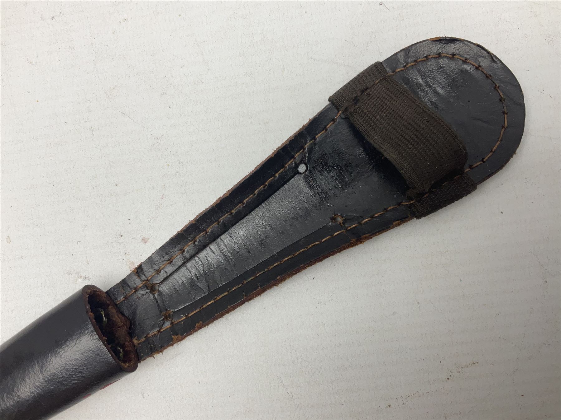 Third Pattern Commando Knife or Dagger with 17.5cm flattened diamond section blade and regulation black painted ribbed copper hilt with brass pommel nut; stamped William Rodgers Sheffield England to the cross-piece; in black painted brass mounted leather scabbard L34.5cm overall