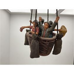 Painted wooden hanging model of a hot air balloon group, the balloon above a wicker basket complete with sandbags and figures, together with a similar example with a clown figure below, H68cm