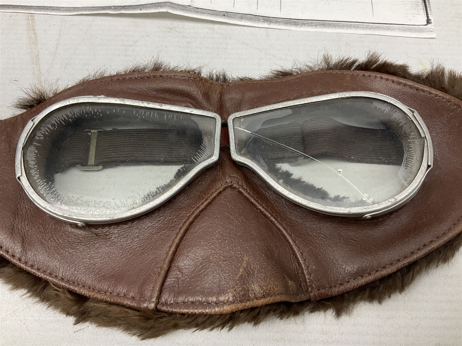 WW1 British Army Derby Scheme 1915 Attested armband; beret with East Yorkshire cap badge; pair of fur lined leather flying/motorcycle goggles; HMS Pembroke cap band; and small quantity of RNAS cloth and metal badges etc