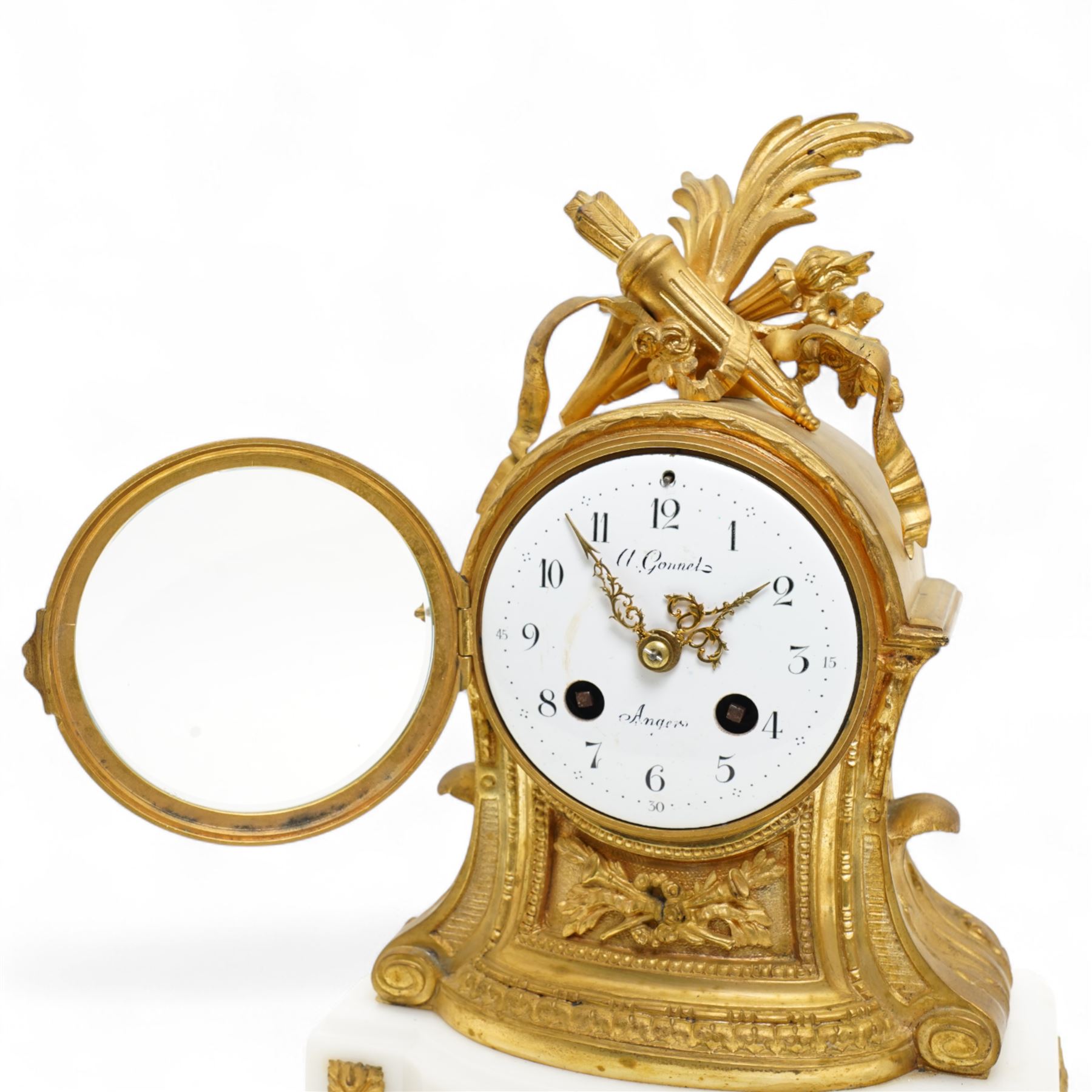 French-Ormolu and white marble mantle clock with garnitures, c 1910, with a white enamel dial and Arabic numerals, indistinct signature, pierced gilt-metal hands and minute markers, 8-day twin train countwheel striking movement, sounding the hours and half-hours on a bell, with a matching pair of two light candelabra. With pendulum and key.