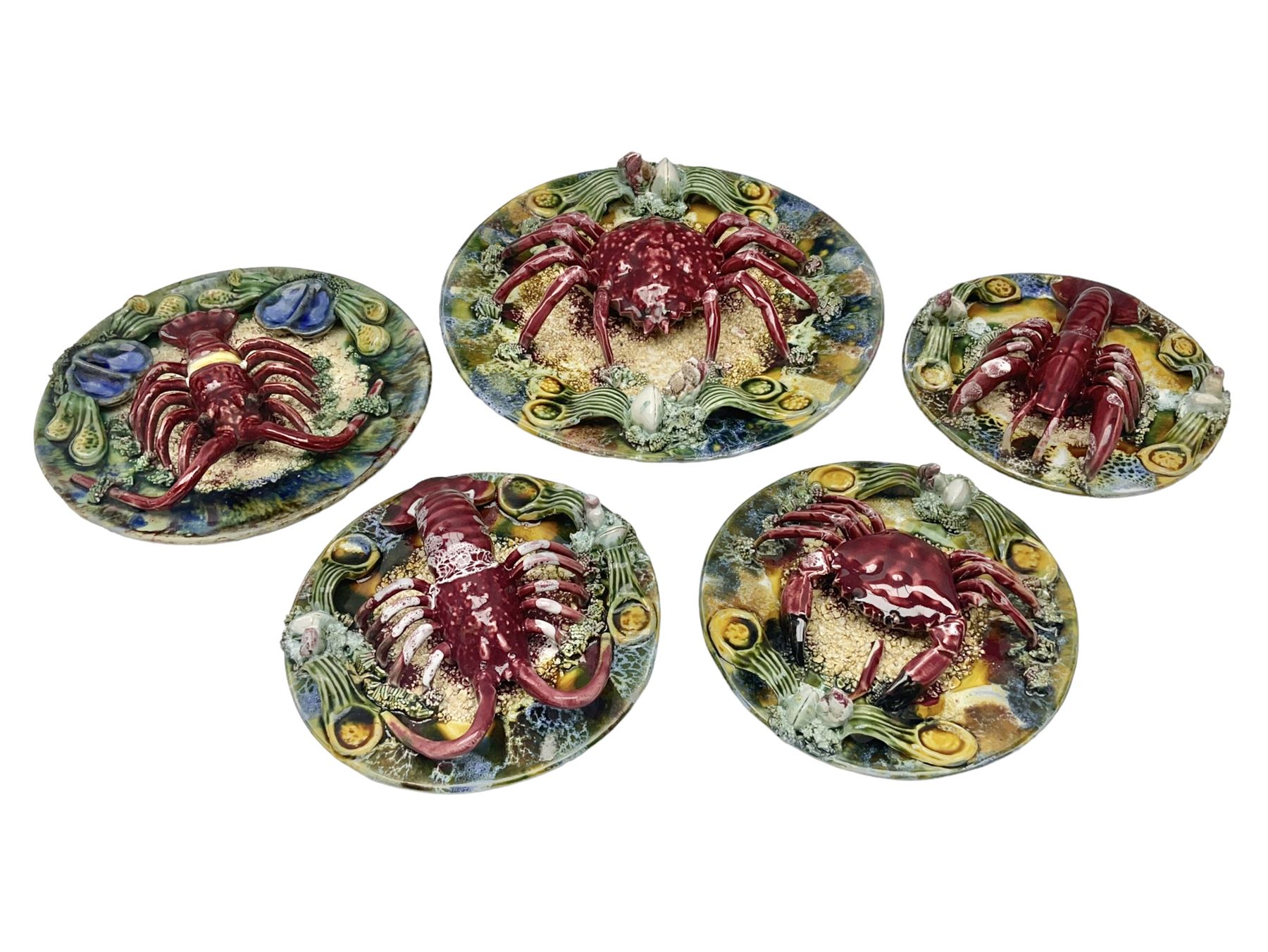 Five 20th Century Portuguese Palissy style Majolica wall plates, all depicting crustaceans to the centre modelled in relief surrounded by encrustations and shells, both with impress marks beneath, largest D29cm