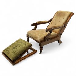 William IV mahogany gentleman's library reclining armchair, leather button upholstered and brass-studded back and seat, above leather-covered arms terminating with carved roundels and foliate scroll-carved ends, underside with brass mechanical trigger reclining lever, the apron with retractable foot rest, supported on lappet carved and turned legs with brass castors, circa 1835