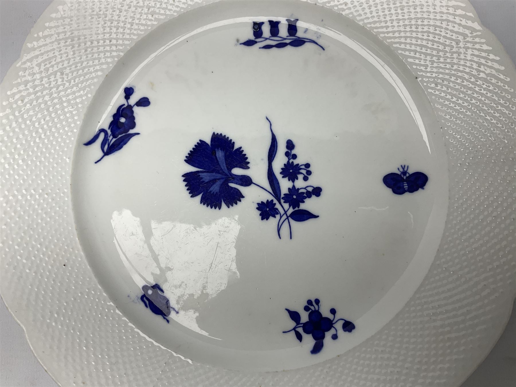 Three 19th century plates, comprising two circular examples and one oblong, each with osier moulded sides, the centres decorated in underglaze blue with Gillyflower type pattern, circular examples D25cm oblong example W27cm