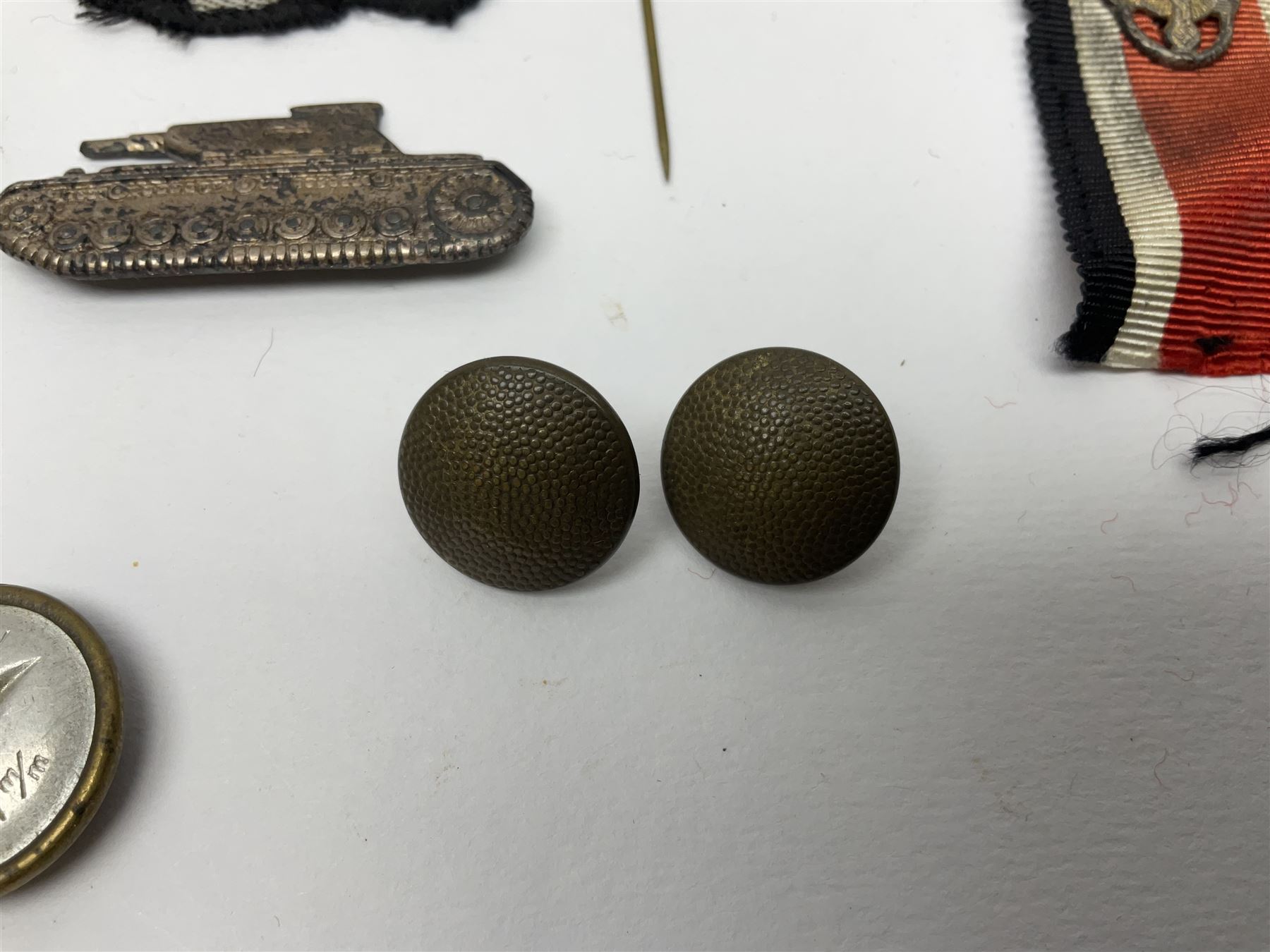 Collection of eleven German metal and cloth badges and uniform buttons including driver's badge, two 'SS' fabric skulls, private's shoulder tabs, Police cloth badge, tank destruction badge, medal bars and ribbon etc; most WW2 period