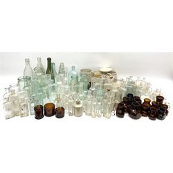A collection of assorted glass bottles, of various size and form, mostly clear and green glass examples, plus a small group of Stoneware jars. 