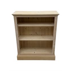 Contemporary light pine open bookcase, rectangular top with stepped moulded edge above a boarded back, fitted with two adjustable shelves, on a plinth base