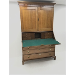 Georgian oak bureau bookcase, projecting cornice, two cupboards above fall front enclosing well fitted interior, six graduating drawers, shaped bracket supports, W135cm, H215cm, D57cm