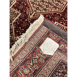 Persian Hamadan rug, lozenge field and decorated with repeating Herati motifs, the band border with repeating design decorated with stylised plant motifs