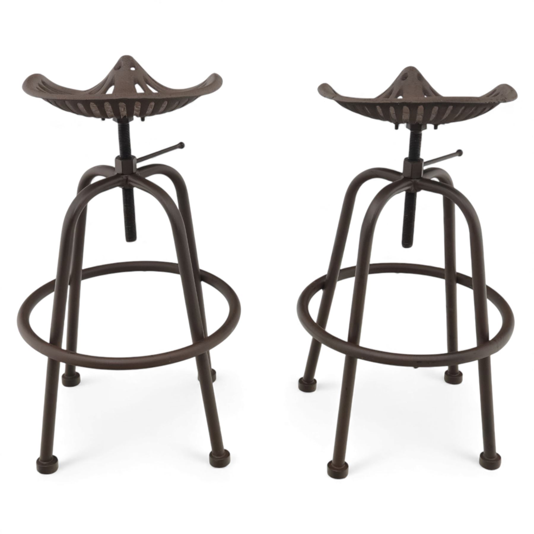 Industrial design pair of cast metal 'tractor seat' revolving bar stools, each with pierced tractor seat shaped top from the early 20th century, raised upon tubular steel supports with circular footrests (Height adjustable from 77cm - 93cm)