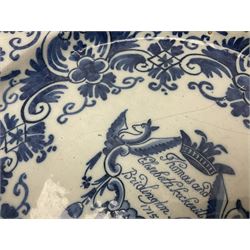 Early 18th century Delft marriage plate, of circular form with dished centre, the centre inscribed and dated 'Thomas and Elizabeth Kockerill Bridlington Key 1715' within a crowned C scroll cartouche, flanked by demi-griffins, above a putto head and tassels, within a wide foliate border, D34cm
