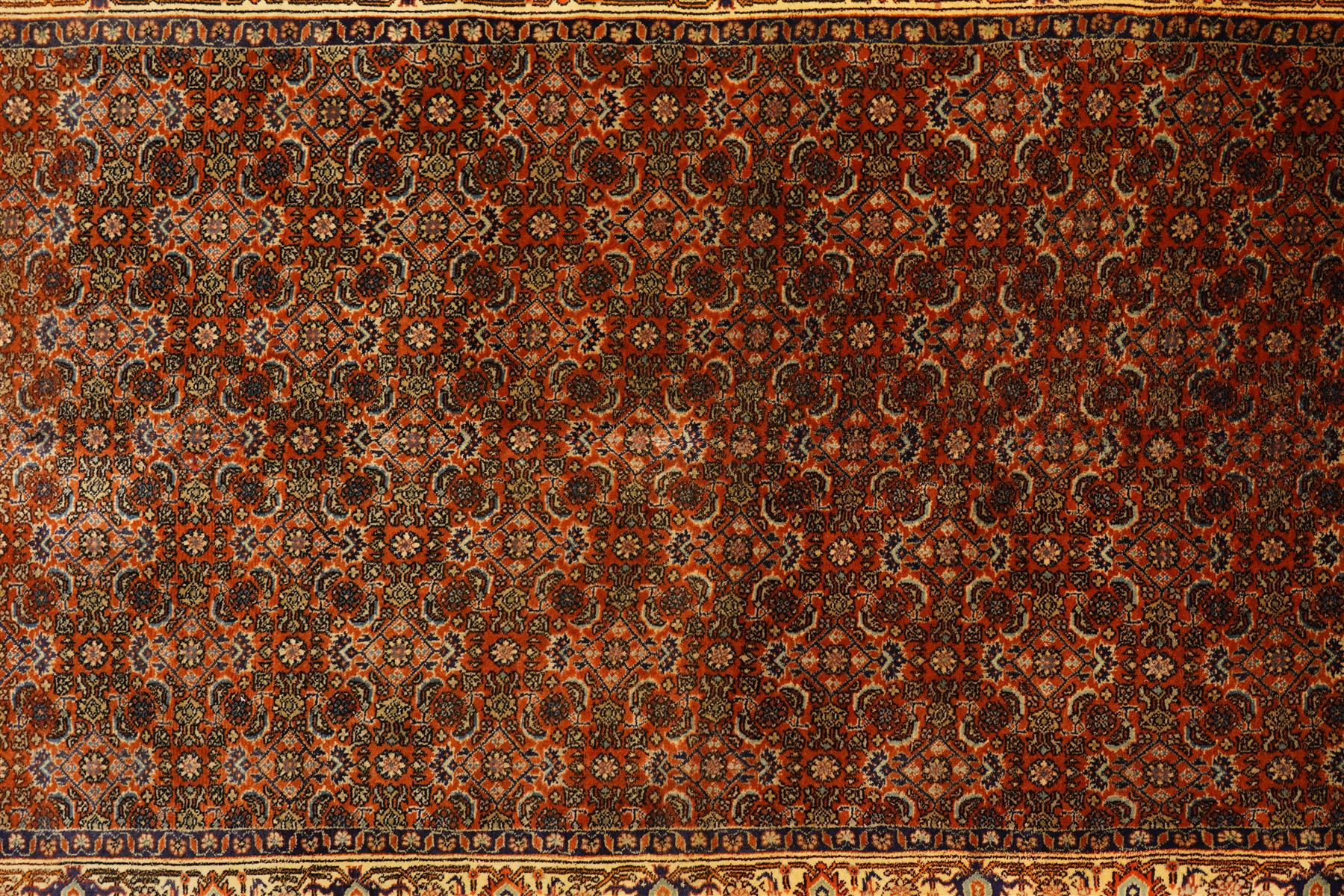 North West Persian Bidjar hand-knotted runner, terracotta field with a repeating mahi design of stylized rosettes and angular floral motifs within a lattice incorporating navy and ivory highlights, ivory principal border with a continuous angular vine of palmettes and serrated leaves, flanked b narrow guard brdoers, with cotton fringe ends 