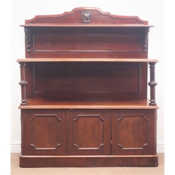  Victorian mahogany three tier buffet sideboard, raised shaped back with carved shield, turned support columns, three panelled cupboard doors enclosing single drawer, plinth base, W140cm, H162cm, D53cm  