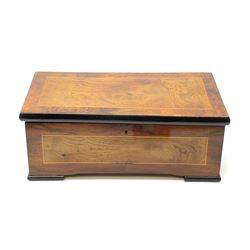 A bur walnut veneered musical box, or regular form with ebonised feet and sides of the hinged opening cover, opening to reveal an ebonised interior, 15cm long cylinder, and comb, box L34cm.