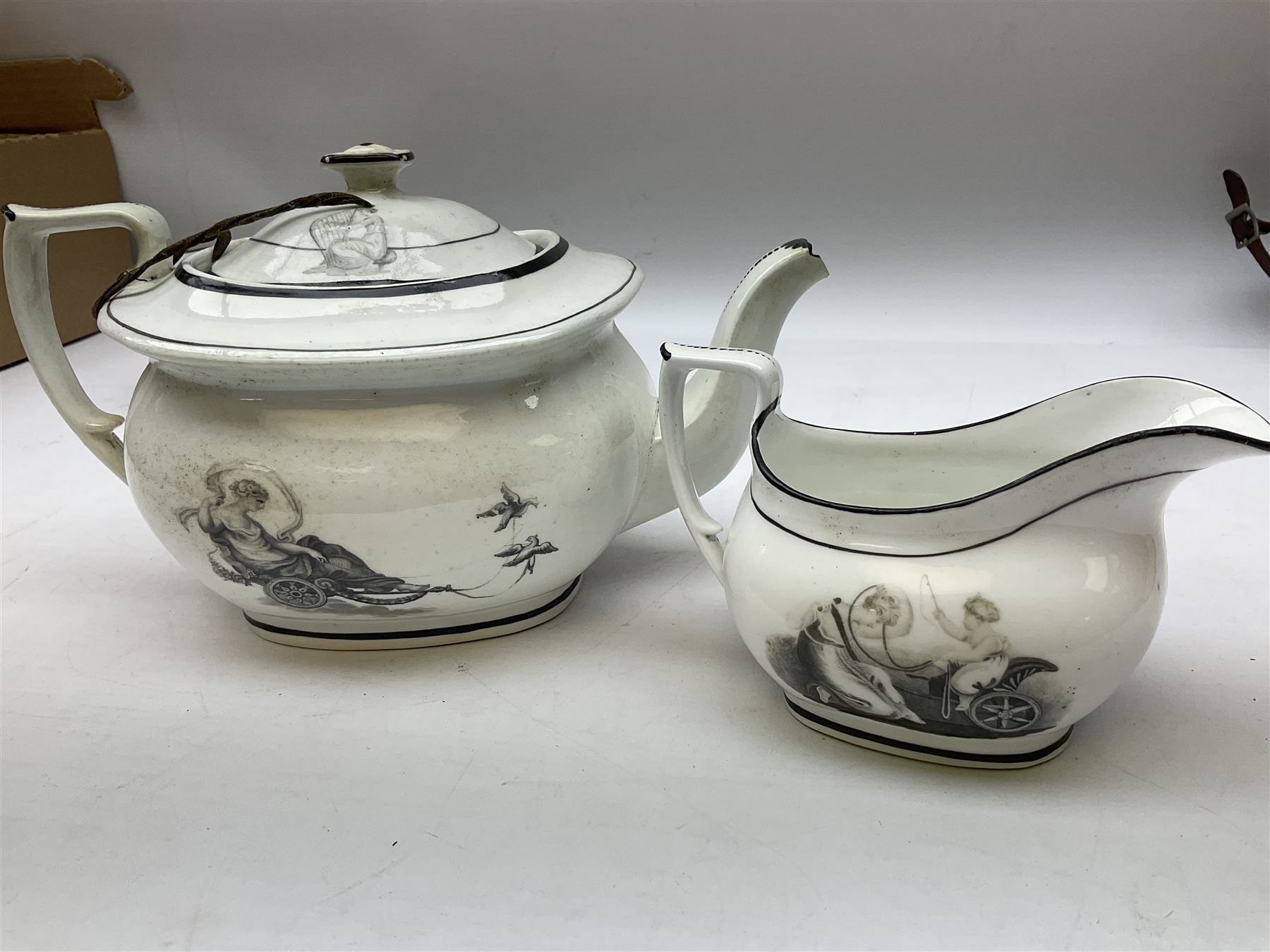 Early 19th century Staffordshire bat printed part tea service, decorated in black after Adam Buck with scenes of mother and child and other varying classical style scenes, within black bands, comprising teapot, slop bowl, jug, seven teacups and five saucers 