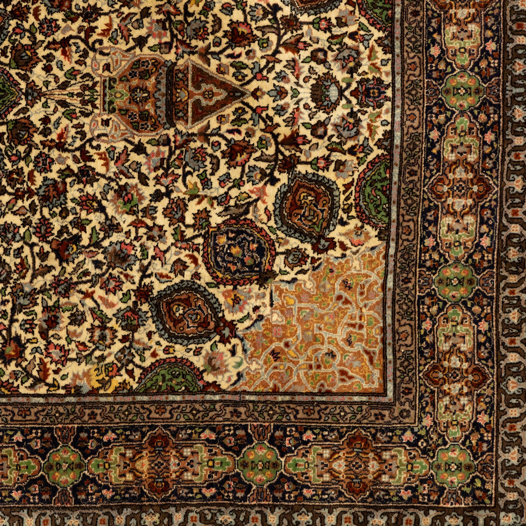 Persian Nain hand-knotted rug, central circular medallion with radiating floral scrolls and palmettes enclosed by ivory field with boteh and foliate motifs, framed by a series of guard stripes and a main border with scrolling arabesques in a midnight blue ground 