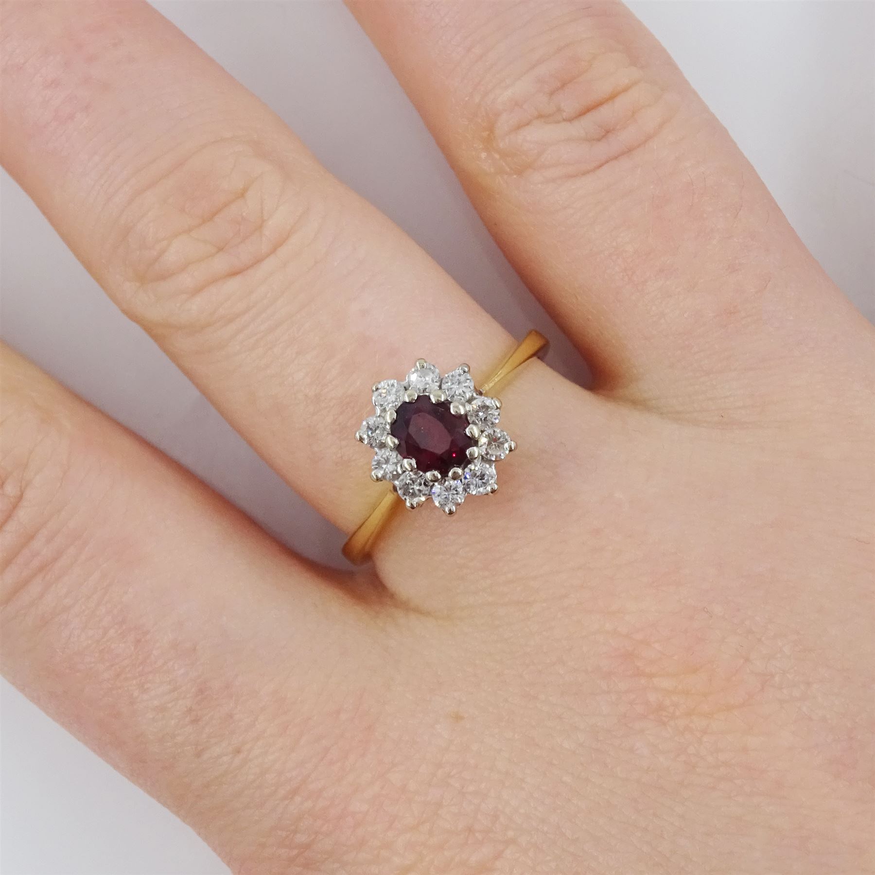 18ct gold oval cut ruby and round brilliant cut diamond cluster ring, London 1976, ruby approx 0.45 carat, total diamond weight approx 0.30 carat
