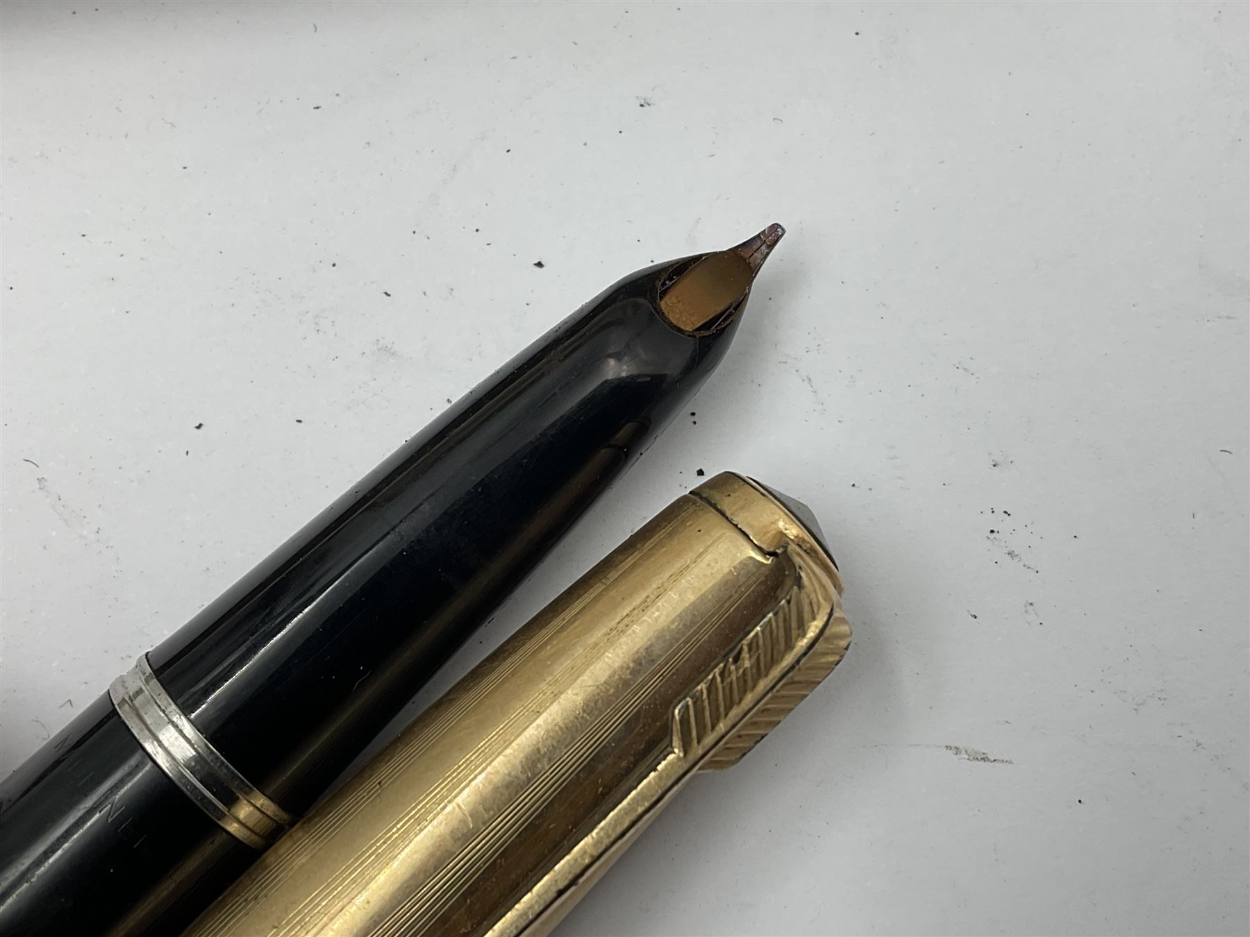 Three parker fountain pens, one example with 14ct gold plated cap and personal engraving, in Parker 51 box, together with a silver Sampson Mordan Everpoint propelling pencil with personal engraving and a silver cased fountain pen with 14ct gold nib and a souvenir bronze Dollfus-Mieg medallion, awarded to John G Sedorski, in fitted case 