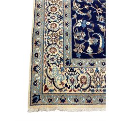 Central Persian Nain carpet, wool and silk inlaid, indigo ground field with central rosette floral medallion, decorated with interlaced branch and stylised plant motifs, repeating trailing floral design border 