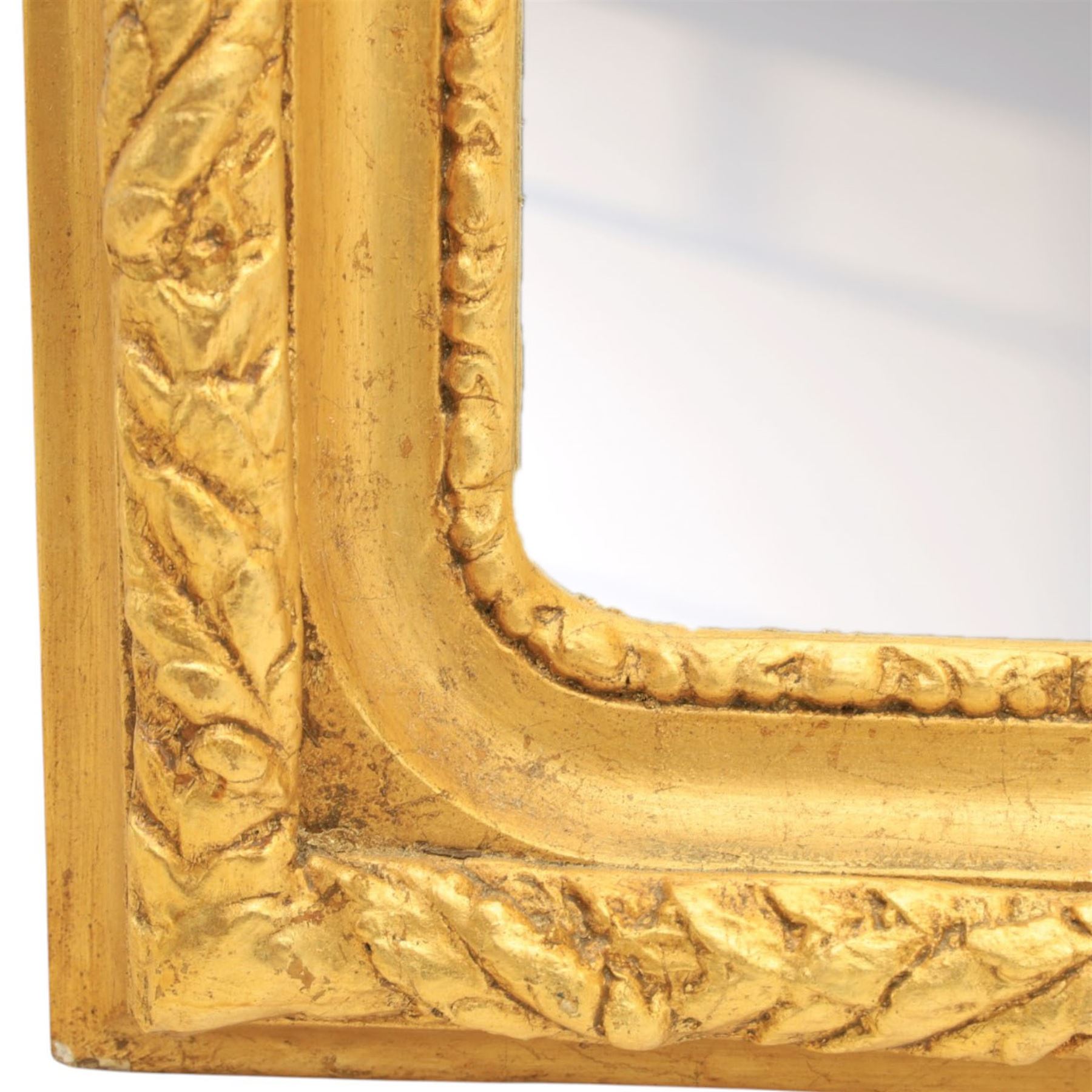 Louis XVI style giltwood pair of wall mirrors, arched frames with moulded borders, surmounted by ribbon tied floral crestings and trailing husk swags, enclosing bevelled mirror plates