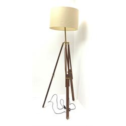 A mahogany and brass mounted tripod standard lamp, with retractable feet, and accompanying cream shade, lamp base when extended approximately H122cm. 