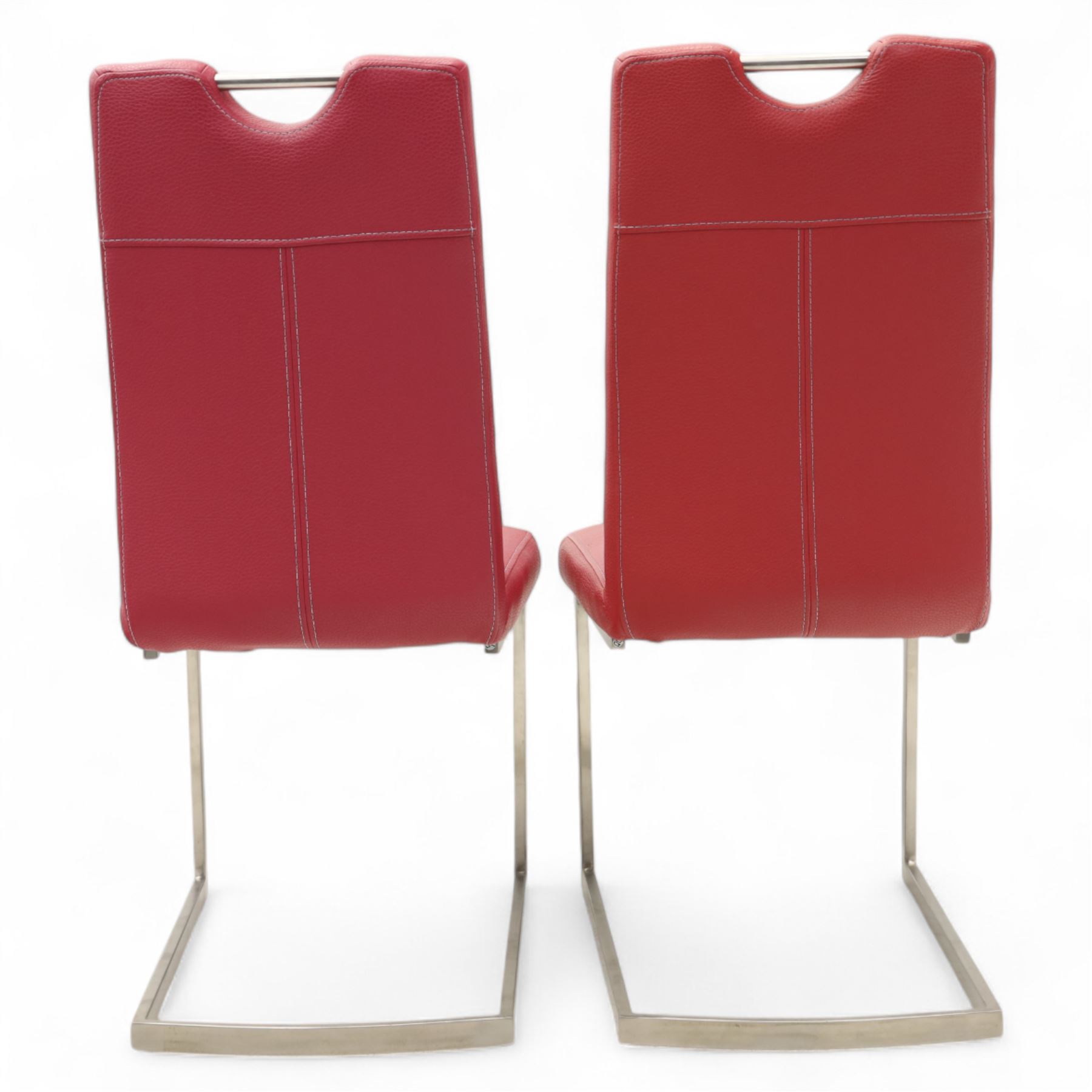 Set of seven contemporary style dining chairs, each with a high padded back and seat upholstered in faux leather on brushed steel sled bases  