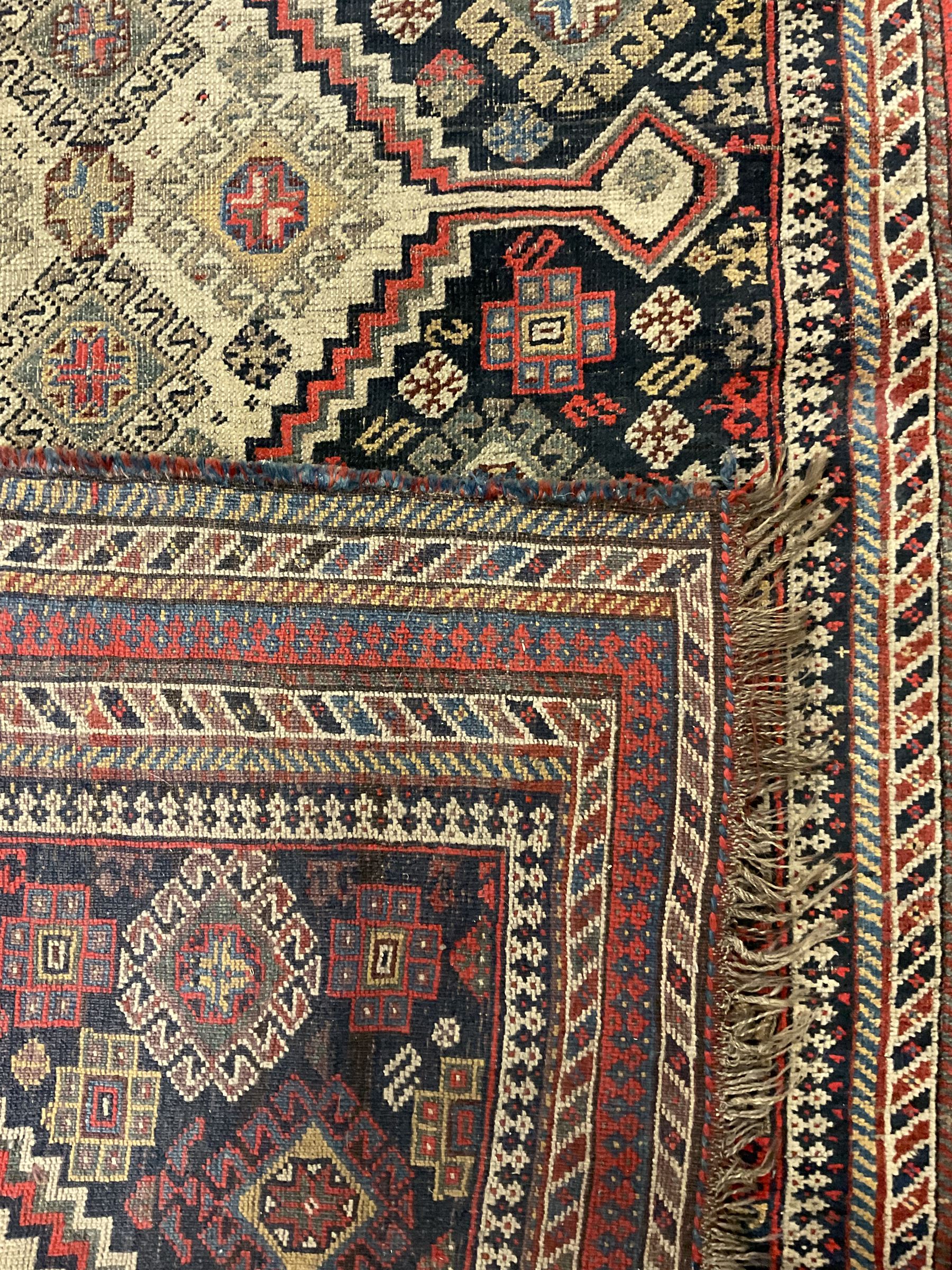 Old Persian Hamadan rug, the indigo ground field with three interlinked lozenge medallions, decorated all over with geometric and stylised motifs, eight band border with repeating geometric patterns 
