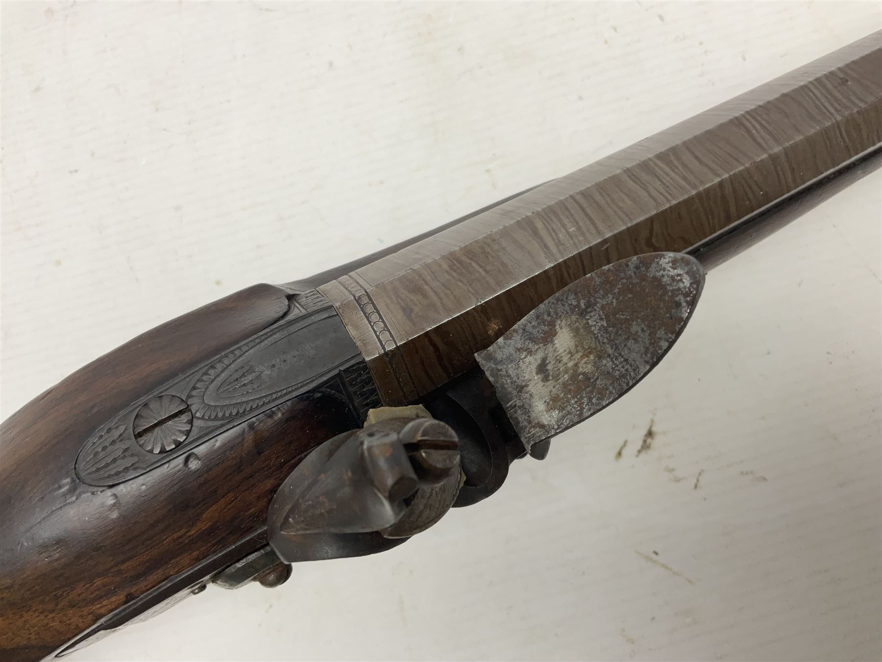 Early 19th century 16-bore flintlock single barrel travelling pistol, the 21.5cm stub twist octagonal barrel with two barrel pins and ramrod under, engraved lock plate with roller frizzen, engraved trigger guard with pineapple finial, walnut stoock with chequered grip L40cm overall