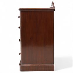Pair of tall Victorian mahogany bedside chests, of narrow upright form, rectangular top with moulded edge, the back with raised pierced fretwork gallery, above four graduated drawers with knob handles, raised on a plinth base 