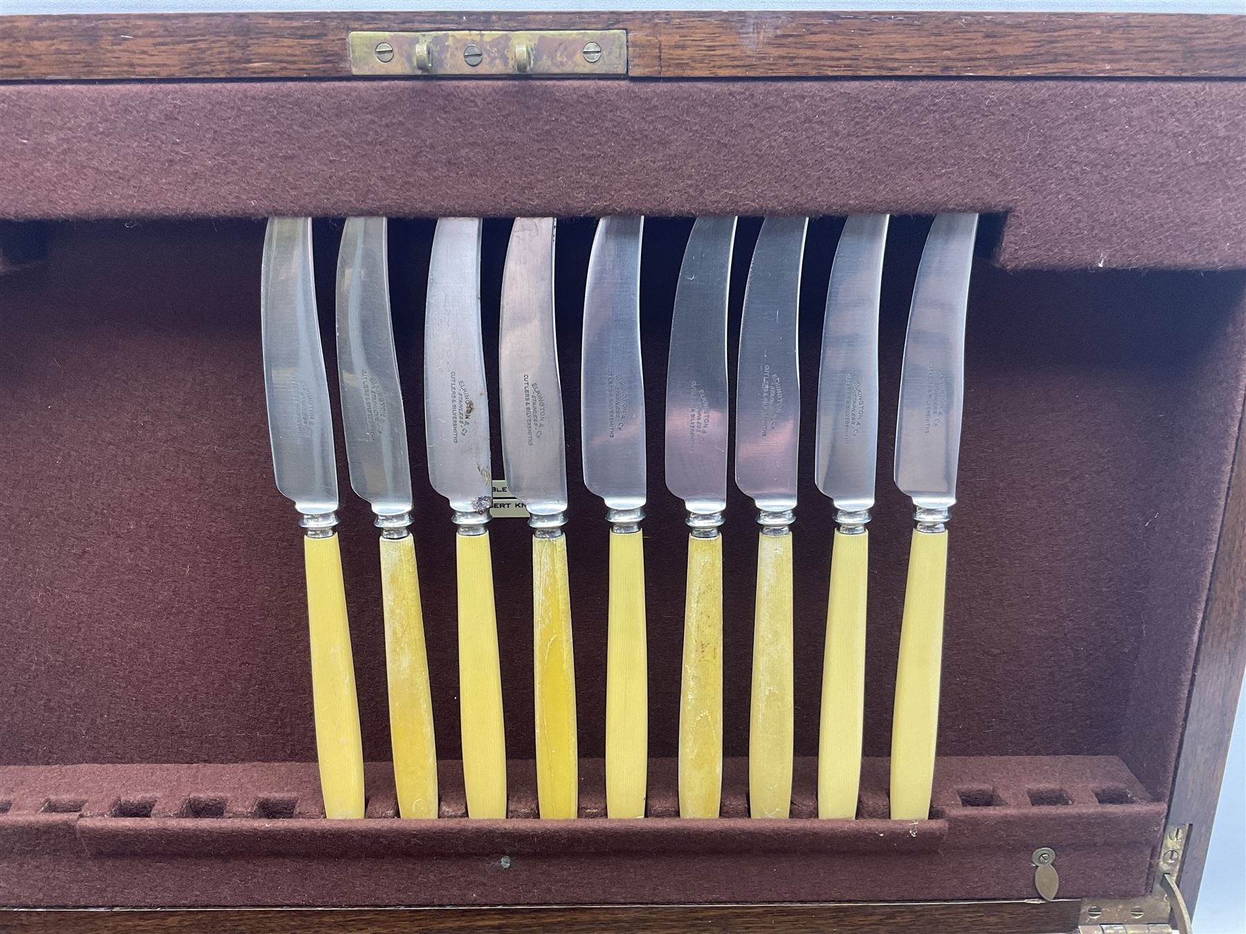 Elkington & Co part canteen of silver plated and stainless steel cutlery, to include simulated ivory handled examples, housed in oak and mahogany case, lock plate stamped 'Acme, British Made', W49cm D31cm H18cm
