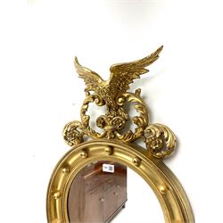 Reproduction Regency style gilt wall mirror, the eagle and leaf scroll pediment over circular mirror plate