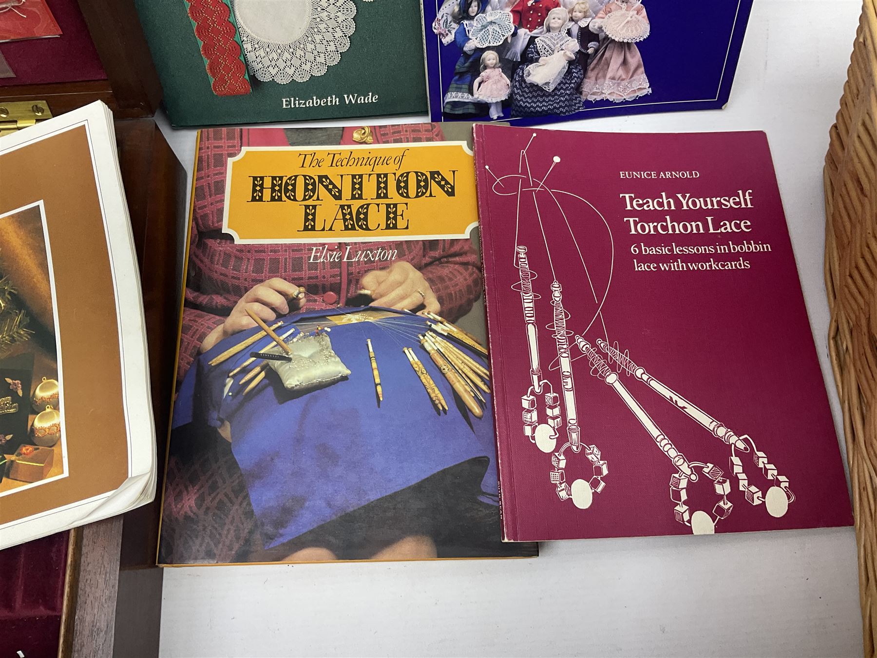 Collection of lace making wooden bobbins, together with lace making books and a handmade storage box