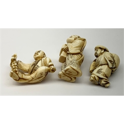 Three Japanese carved ivory netsukes, each modelled as a male figure, seated figure holding a bunch of grapes, signed beneath, largest H5cm, together with a Japanese ivory Manju, the front detailed with a figure and Koi fish, (a/f), D4.5cm. 