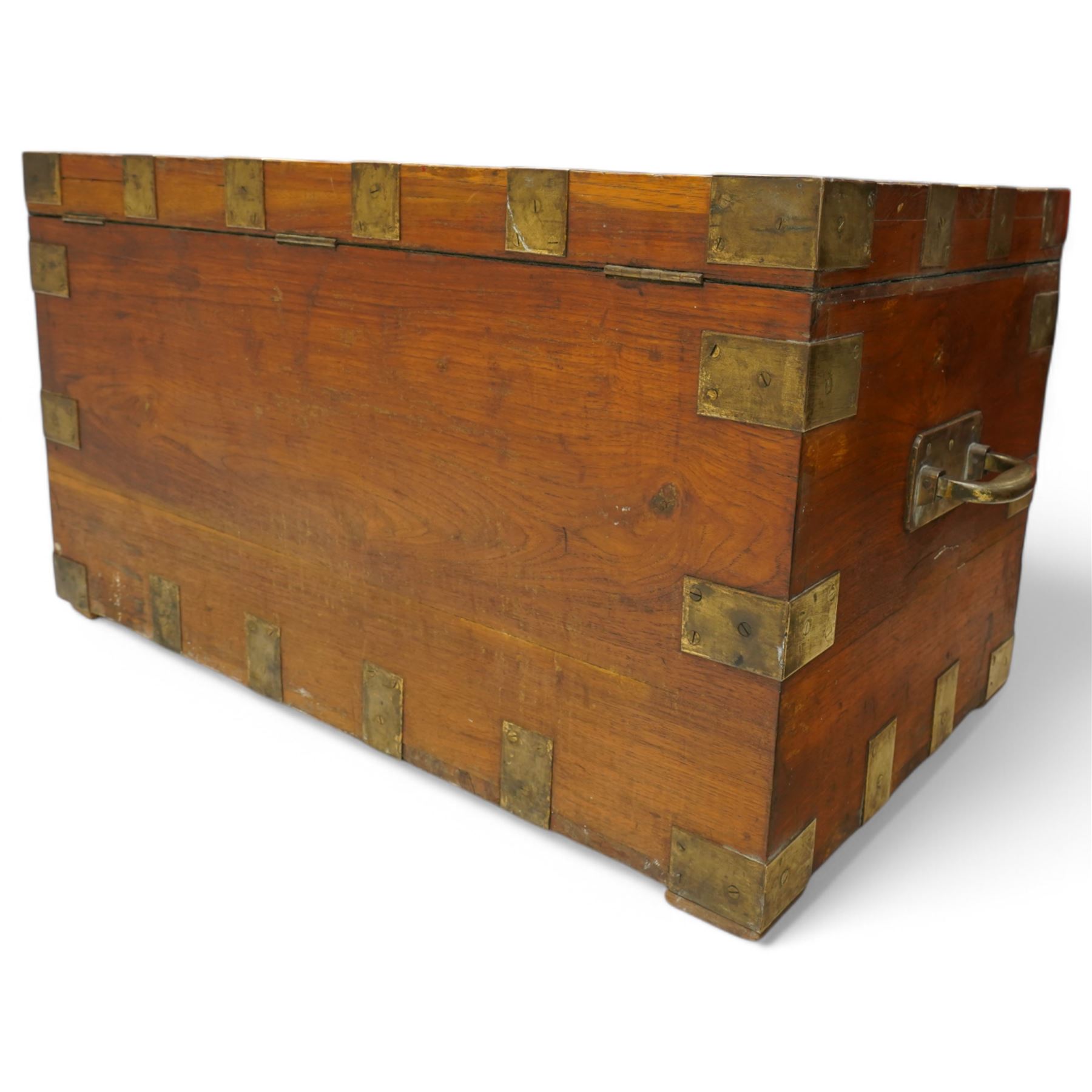 Early 19th century teak and brass bound silver campaign chest, fitted with brass L-shaped brackets and heavy weight carrying handles, the hinged lid enclosing two removeable trays with divisions and lined in blue baize, fitted with two 'R. Cooper & Son' brass locks