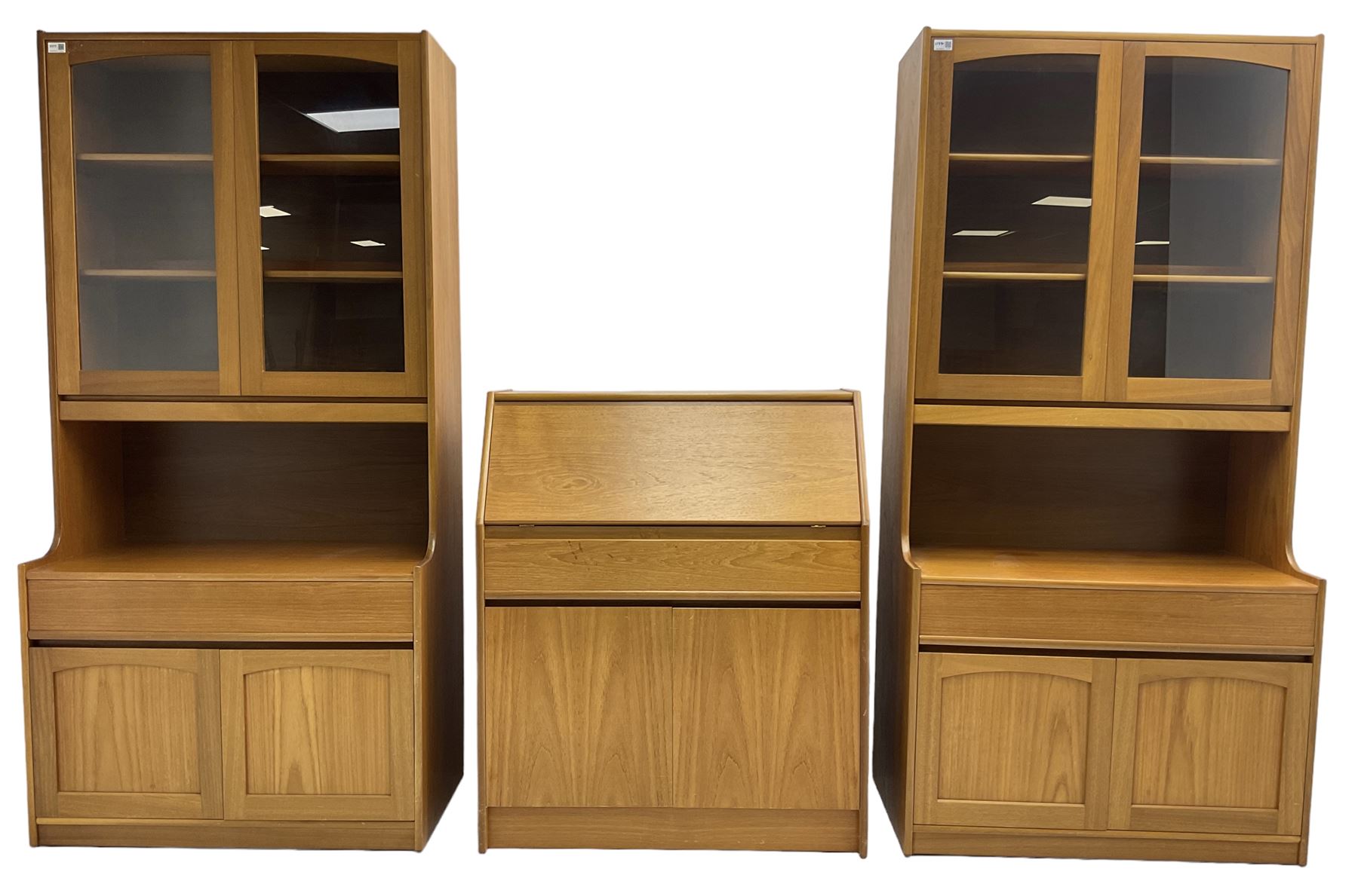 Sutcliffe of Todmorden - pair of teak wall units, fitted with two glazed doors over drawer and double cupboard (W86cm, D45cm, H198cm); and a matching fall front bureau (W84cm, D41cm, H100cm)