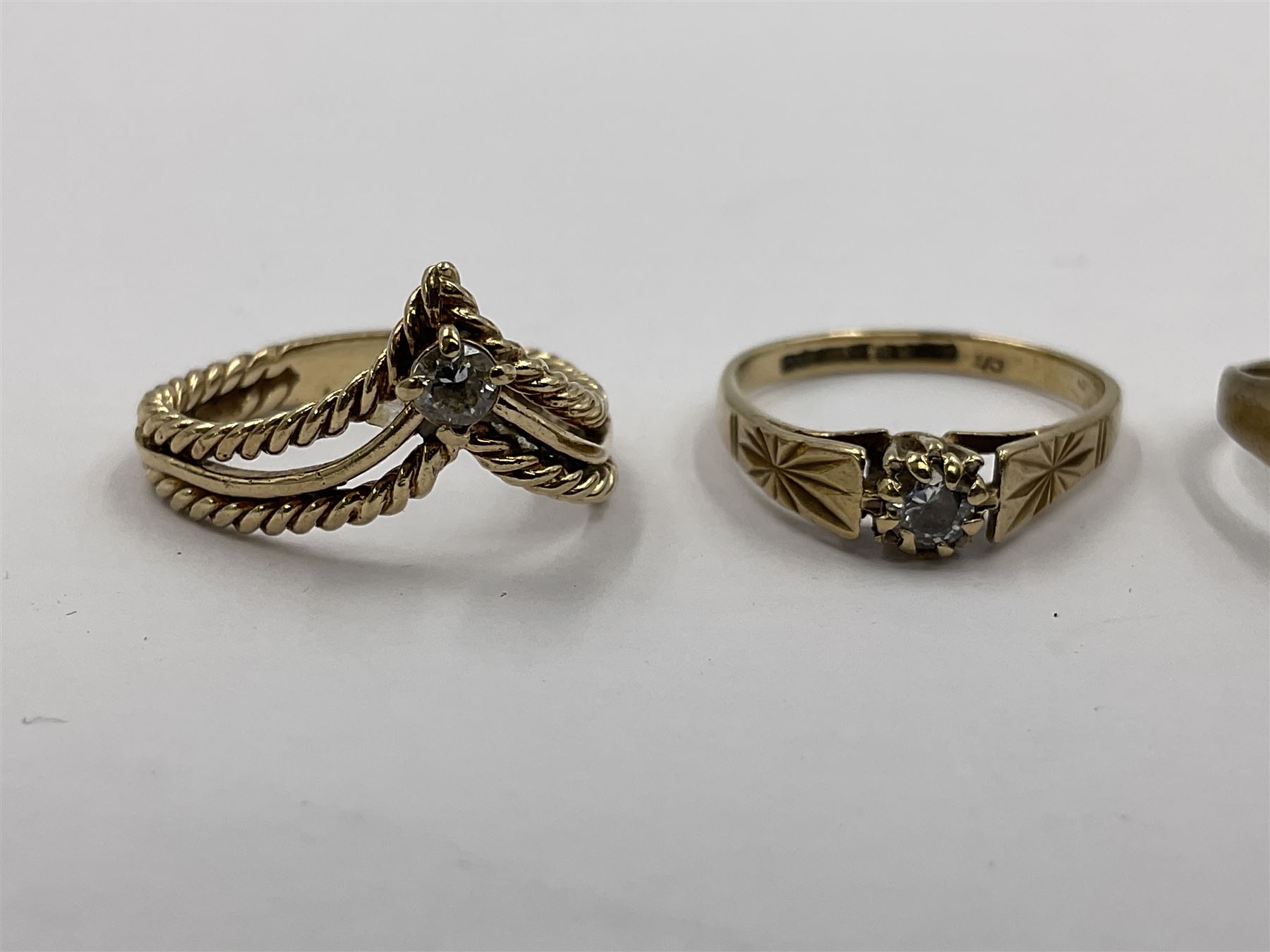 Four 9ct gold rings, to include cubic zirconia wishbone ring, single stone cubic zirconia ring and two heart design signet rings
