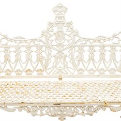 Victorian revival heavy cast iron garden bench, ornate back rest with scrolls, floral motifs and central crest, pierced lattice seat, curved arms and decorative legs, painted in antique white, in the Gothic Coalbrookdale style