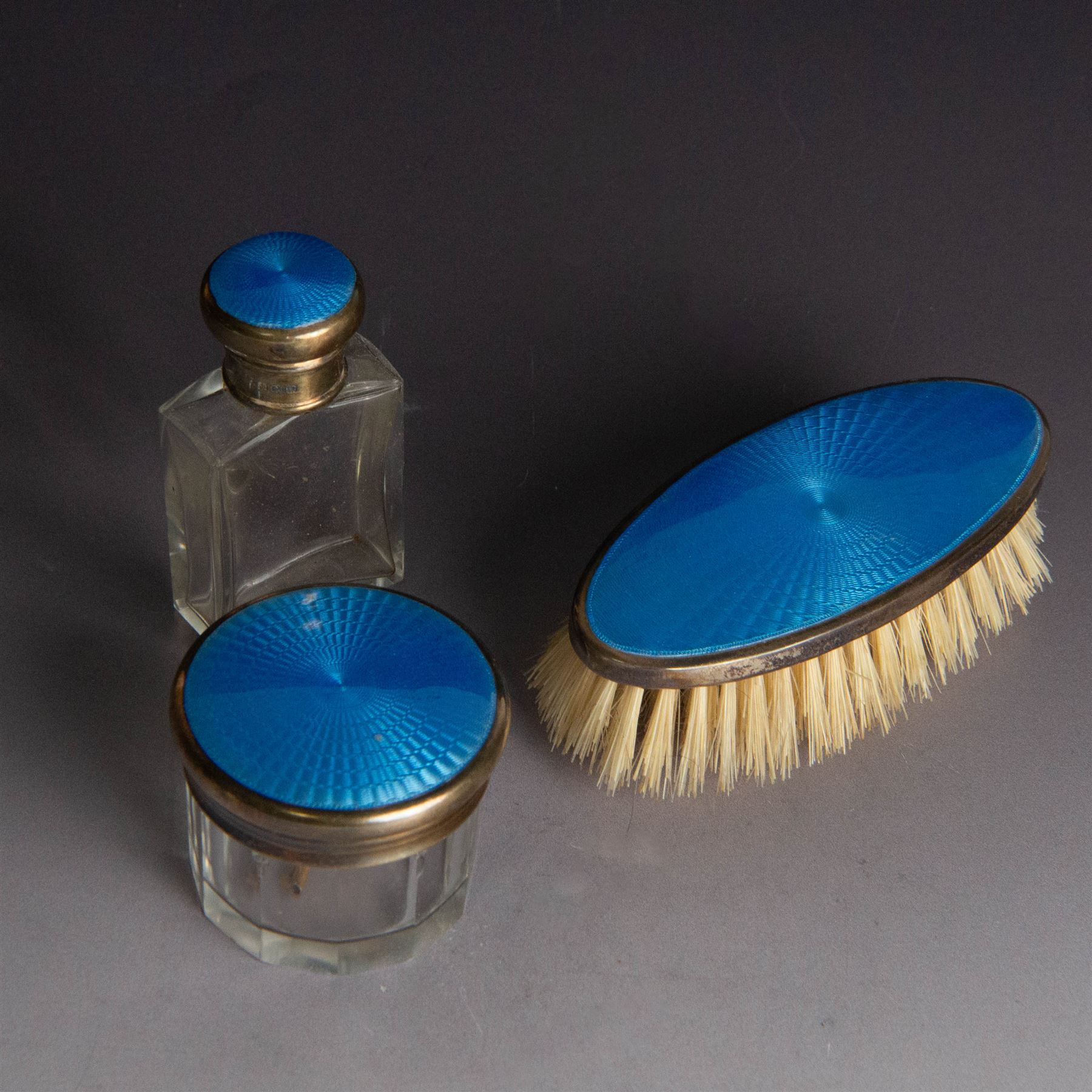 1920s silver mounted blue guilloche enamel travelling dressing table set, comprising hairbrush, comb, bottle and jar, hallmarked RWF Ltd, Birmingham 1927, contained withing tooled leather fitted case with bevelled mirror to interior