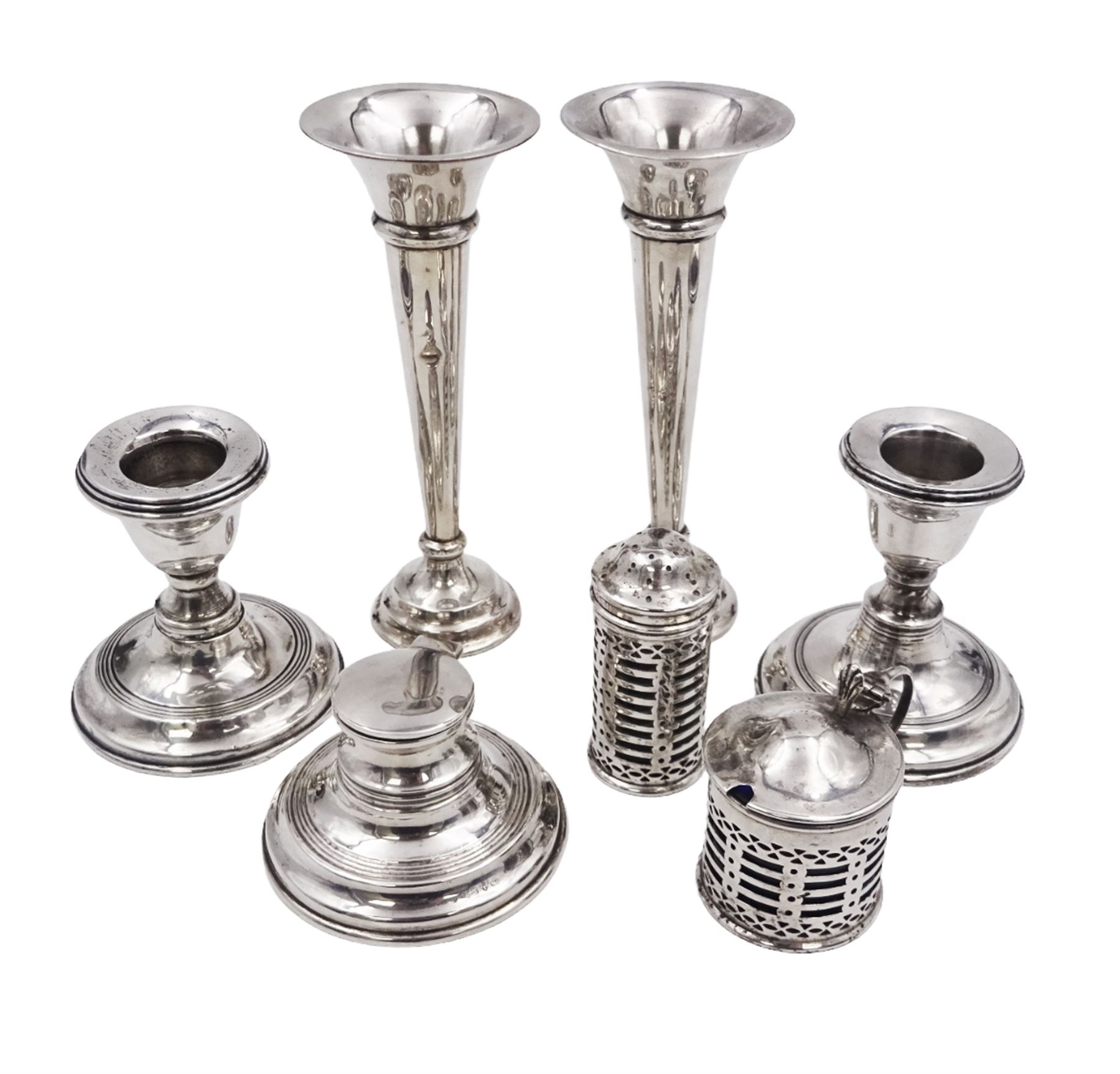 Group of early 20th century silver, to include a pair of specimen vases, of plain trumpet form, upon knopped stem and filled stepped circular foot, hallmarked J & R Griffin, Chester 1915, pair of silver mounted dwarf candlesticks, hallmarked J & R Griffin, Chester 1909, small silver mounted capstan inkwell with glass insert, hallmarked Chester 1909, maker's mark worn and indistinct, silver pepper, with pierced decoration, hallmarked S Blanckensee & Son Ltd, Birmingham 1909 and a similar mustard pot and cover, hallmarked S Blanckensee & Son Ltd, Chester 1909, both with blue glass liners
