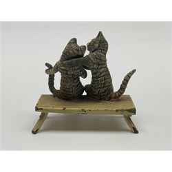 After Bergmann, two cold painted bronze figures, the first modelled as two cats on a bench hugging, the second a cat caning a kitten
