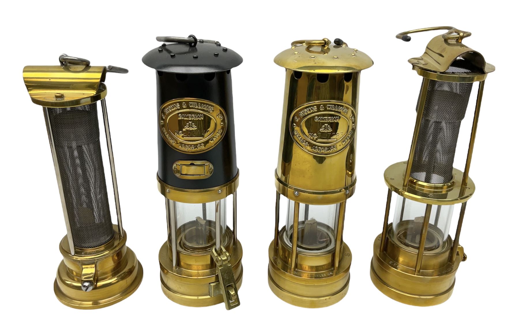 Four miners lamps, comprising Clanny miners lamp, with flip top and gauze protected by three rods, stamped E.T.W E-3, lamp with a gauze chamber protected by three rods, and two E. Thomas & Williams Ltd lamps, tallest example H26cm