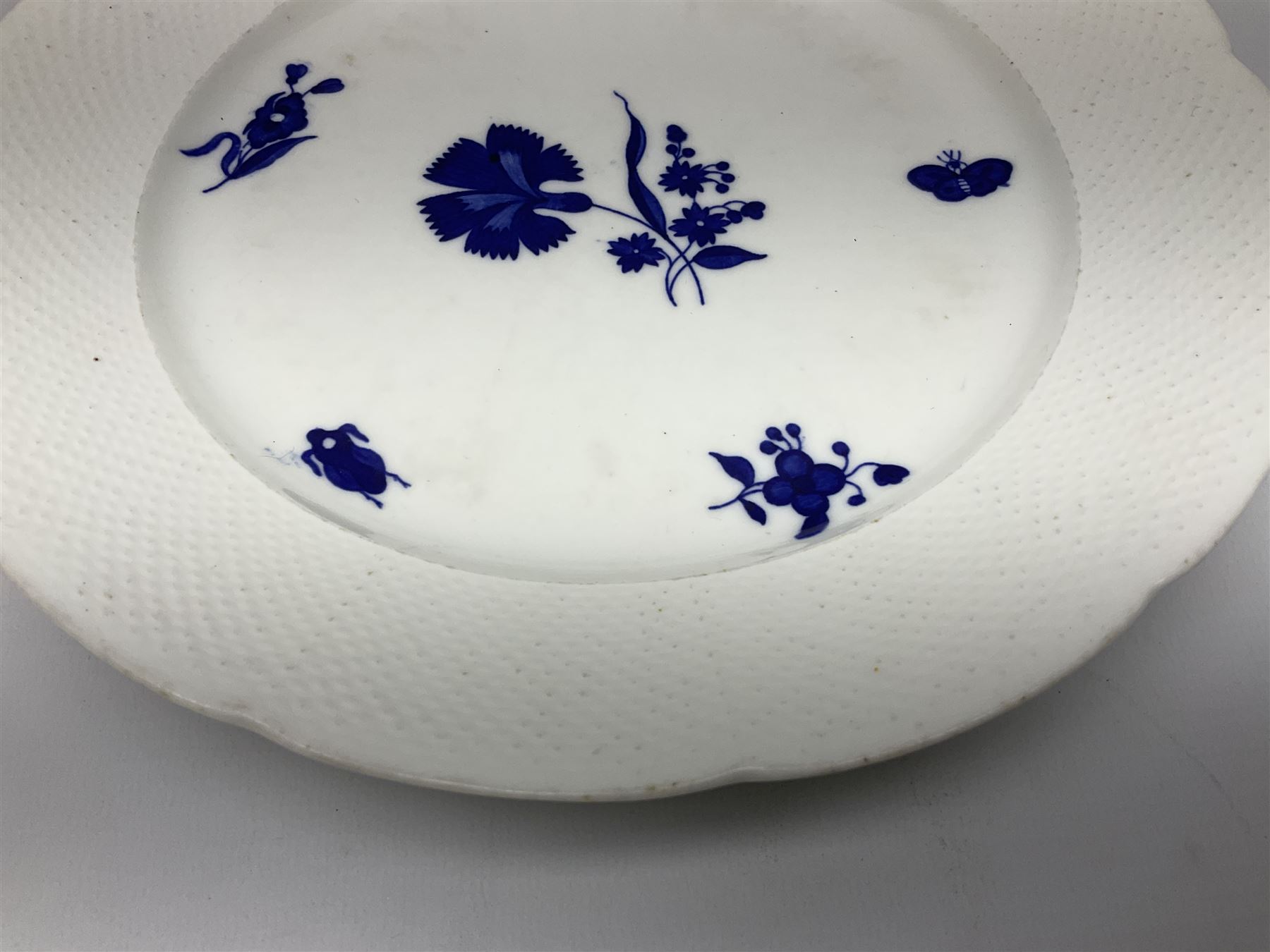 Three 19th century plates, comprising two circular examples and one oblong, each with osier moulded sides, the centres decorated in underglaze blue with Gillyflower type pattern, circular examples D25cm oblong example W27cm