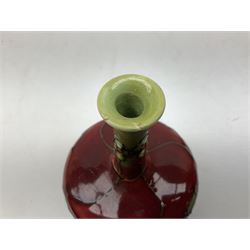 Three Minton Secessionist vases, with tube-lined stylised flower decoration, two upon a red ground and third upon a purple ground, all with printed mark to base 'Minton Ltd, No. 33', H13cm