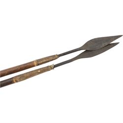 Maasai shield, made of hide, with white, red and black pigment decoration, the back attached to a wooden frame with hide stitching, together with two Maasai spears, shield H70cm, spears L120cm