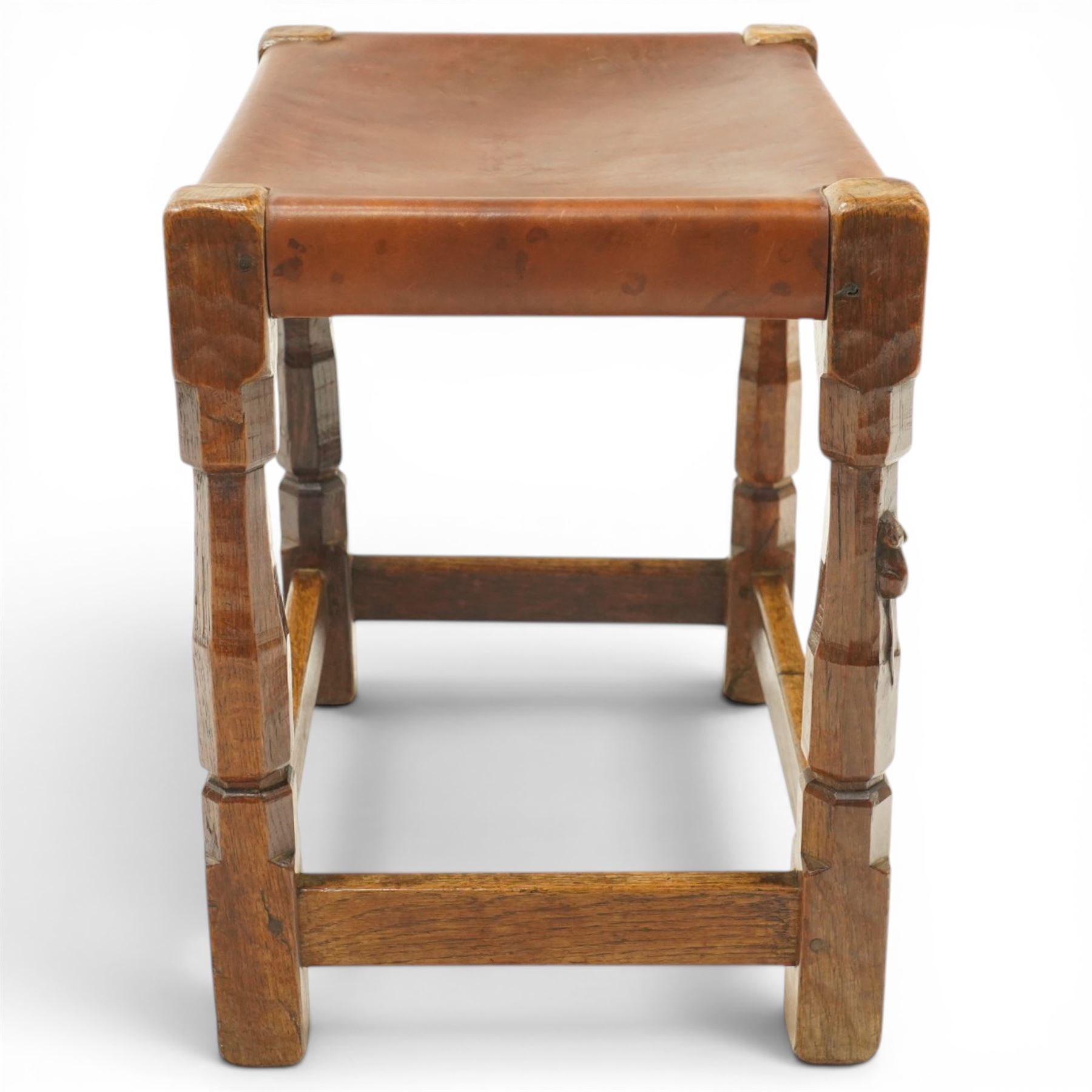 Mouseman - 1940s dark oak dressing table stool, the rectangular top with deep-tan leather seat, raised on octagonal supports united by box stretcher, with carved mouse signature, by the workshop of Robert Thompson of Kilburn