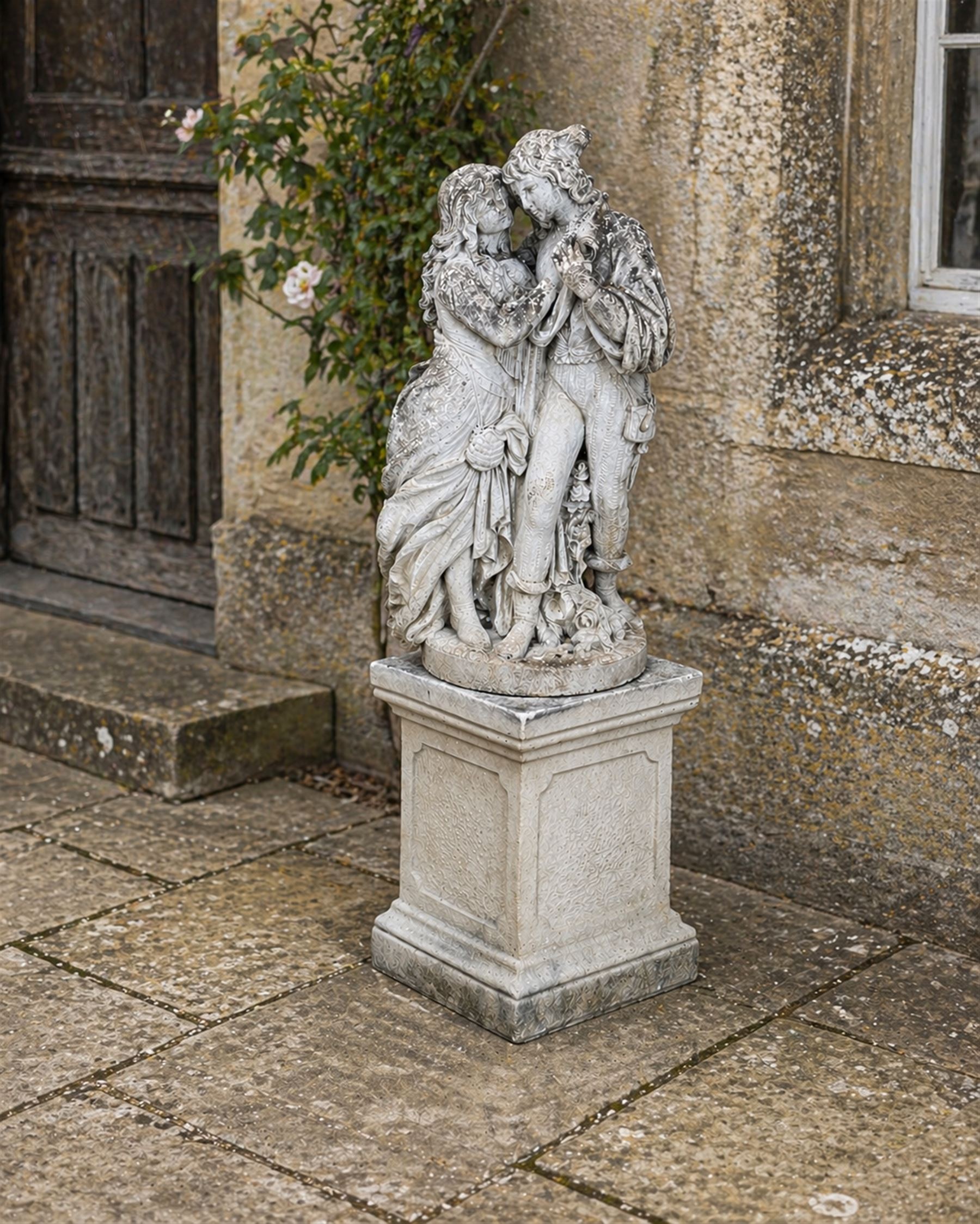 Romeo & Juliet ornate cast stone garden figure, raised on square plinth base