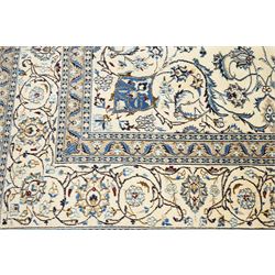 Central Persian Nain hand-knotted carpet, ivory field with central radiating medallion, issuing an all-over design of scrolling vines, palmettes, and delicate floral sprays with conforming spandrels, enclosed by a foliate border, framed by multiple guard stripes, with cotton fringe ends 