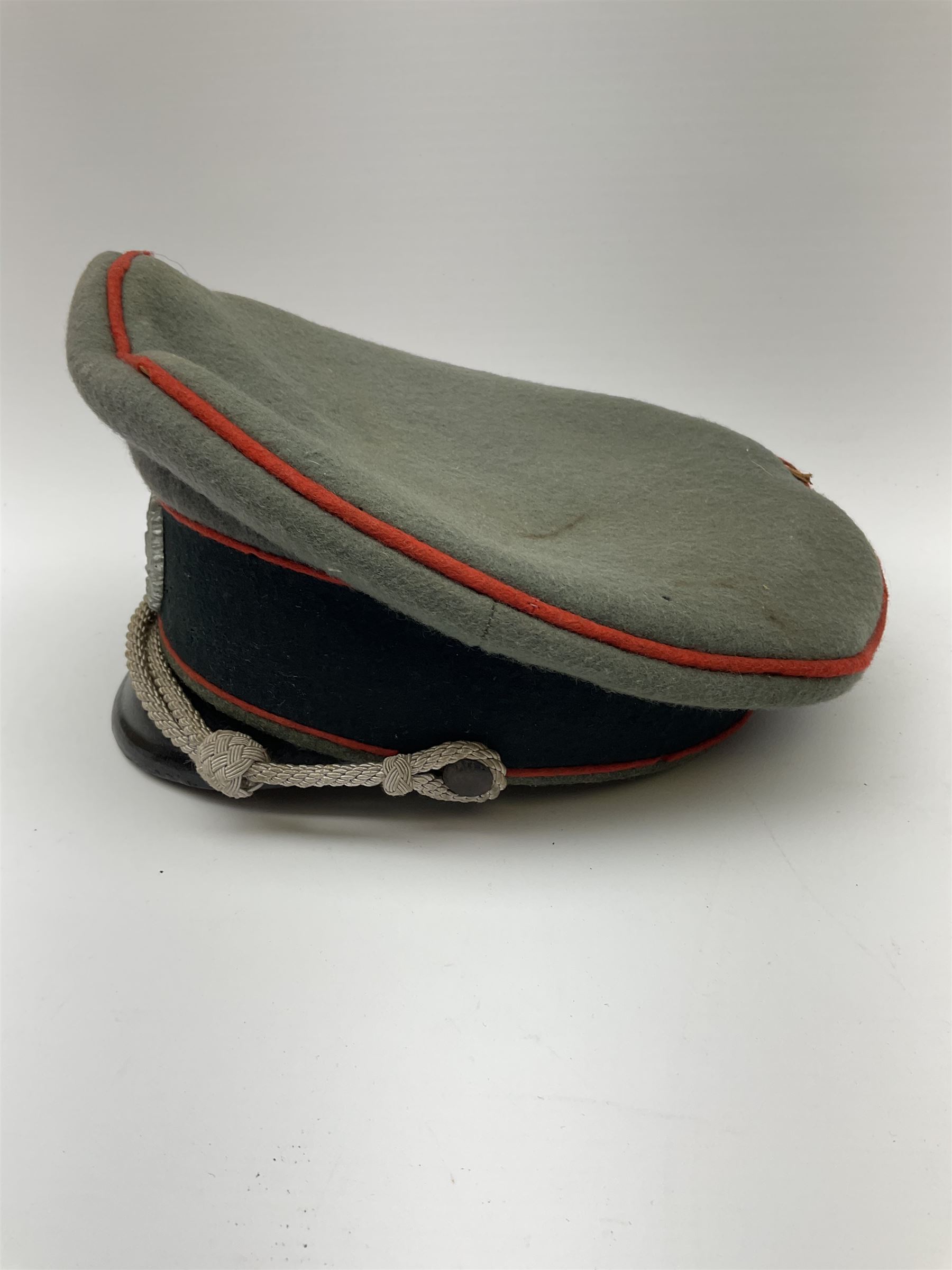 WW2 German Army Artillery officer's peaked cap, red piping to the crown and bordering the central band, zinc eagle and aluminium cockade insignia, officer's bullion chin cords, interior retains original sweatband and lining has tailor's celluloid diamond with 'Extra Klasse' logo and 'Marke Standard'