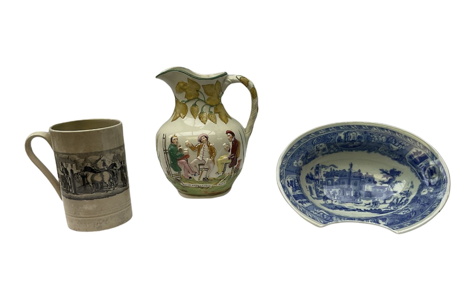 19th century Staffordshire pottery jug, entitled Willie Brewd a Peck o maut, depicting figures in relief, H24cm, a blue and white Victoria Ware Ironstone shaving bowl, L27.5cm, and a 19th century French Sarranguimes tankard with black transfer printed band depicting figures and horses, H17cm
