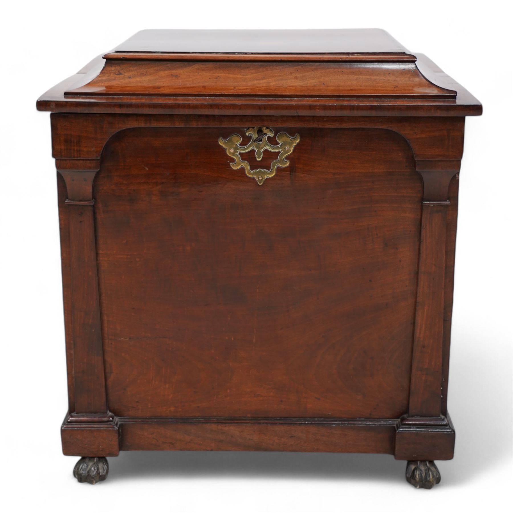 William IV mahogany cellarette, the rectangular hinged sarcophagus top enclosing bottle dividers and metal liner, the front applied with flanking flat pilasters, fitted with pressed brass handle plates escutcheon, lower moulded edge over brass hairy paw feet