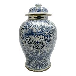 18th century Chinese porcelain jar and cover, of baluster form painted in underglaze blue with phoenix amongst stylised fruiting branches beneath a cloud scroll border, H43cm